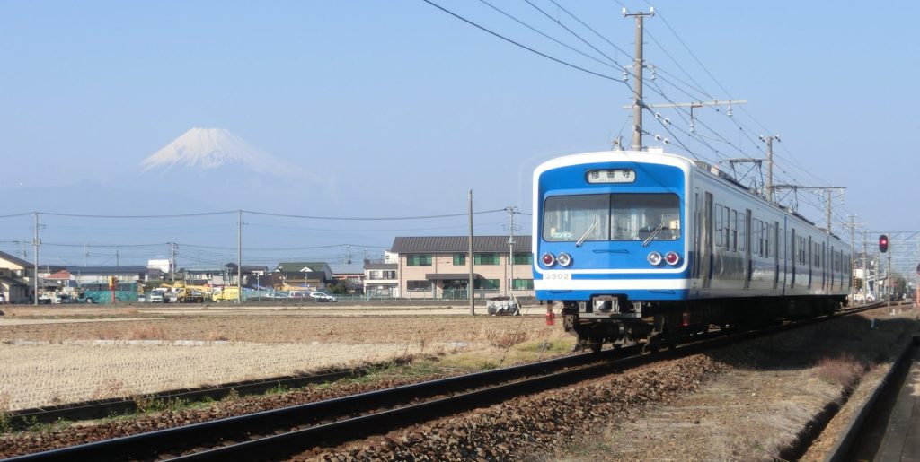 富士山と空を背景に原木駅から電車が向かってくる